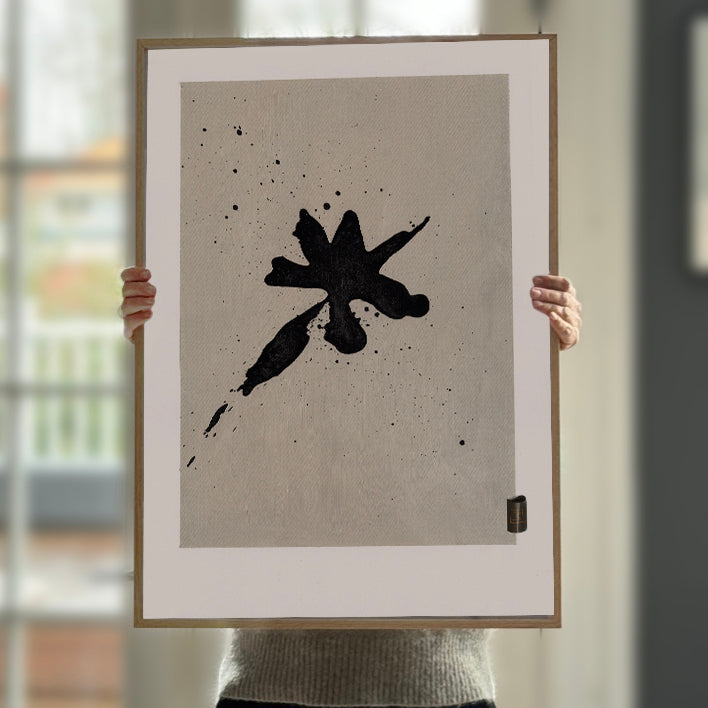 En minimalistisk kunstplakat med en sort blækplet på en lys baggrund, inspireret af den japanske kunstform sumi-e.