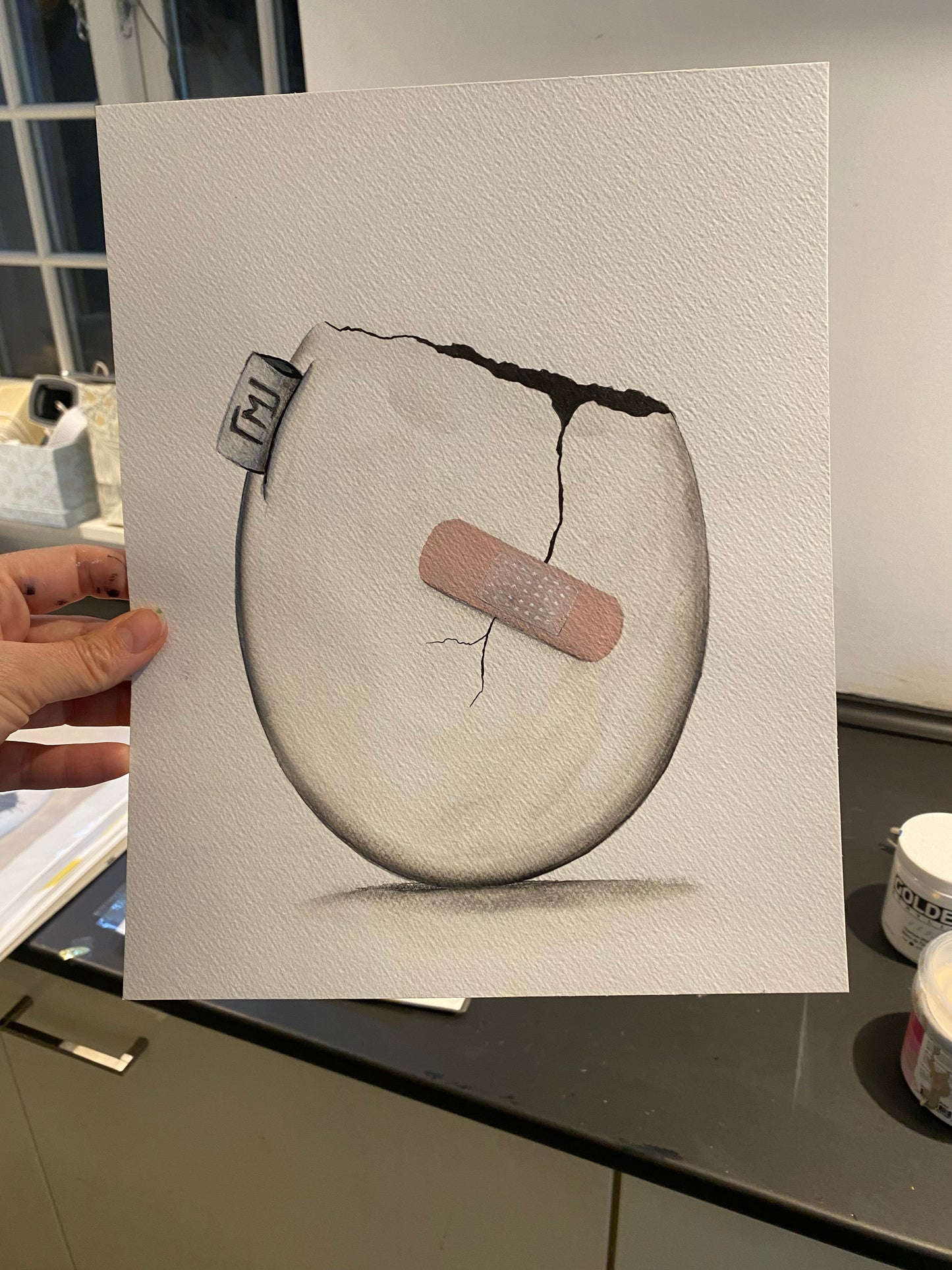 Minimalistisk maleri af æg med revne og plaster, original kunst fra 2022 af Maria Lundsten