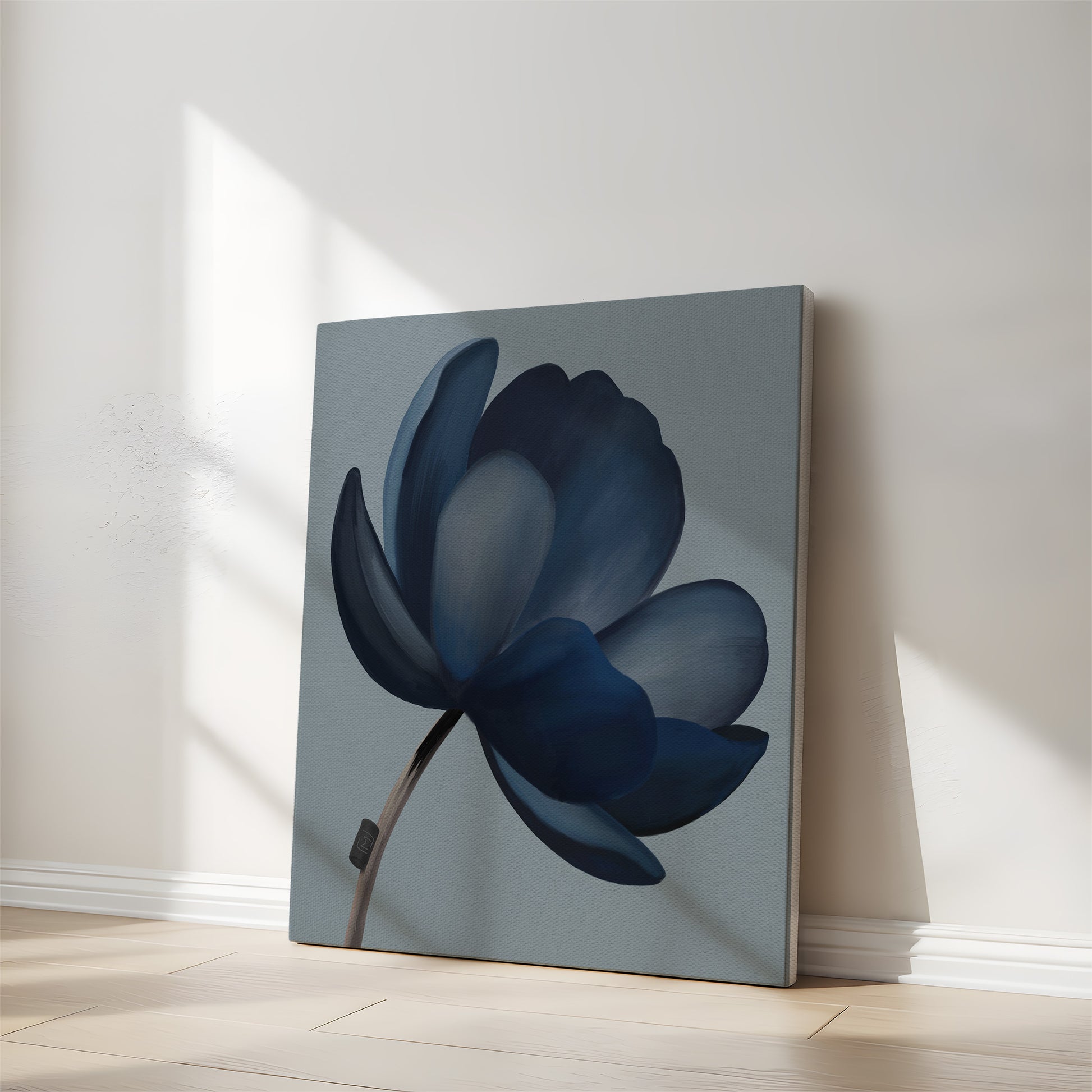 Moderne abstrakt kunst i bløde blå farver lænet op ad væg i lyst rum med naturligt dagslys.
