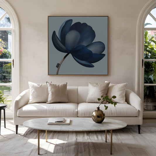 Abstrakt kunstværk i afdæmpede blå nuancer ophængt over lys sofa i nordisk stue med rolig og elegant indretning.