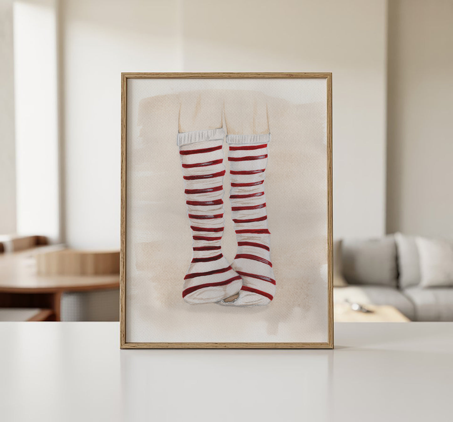 Original illustration med rødstribede strømper i ramme hængt på væg i stue