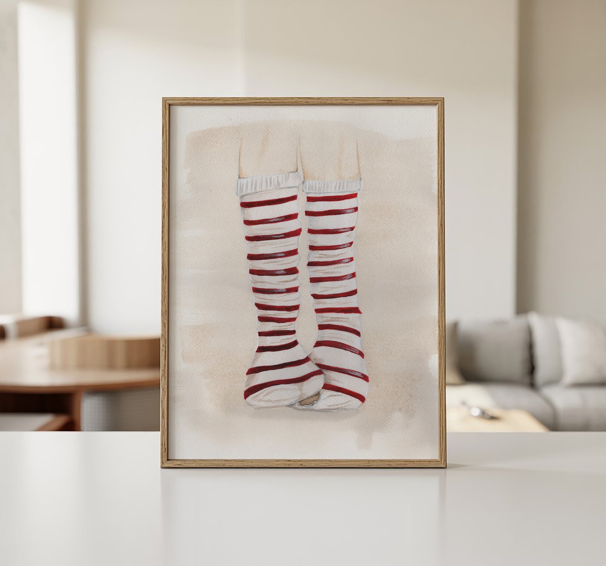Original illustration med rødstribede strømper i ramme hængt på væg i stue