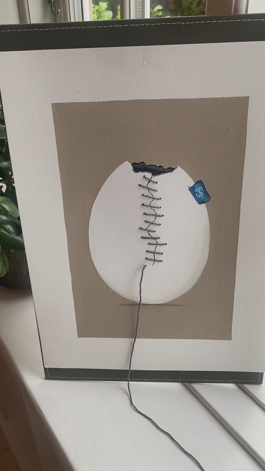 Originalt kunstværk med et revnet strudseæg syet sammen med fin bambustråd. Ægget er malet med akryl og blyant på kraftigt kunstpapir og har et roligt, humoristisk udtryk. Ægte tråd skaber synlig tekstur og dybde i værket, som passer ind i moderne nordisk indretning.