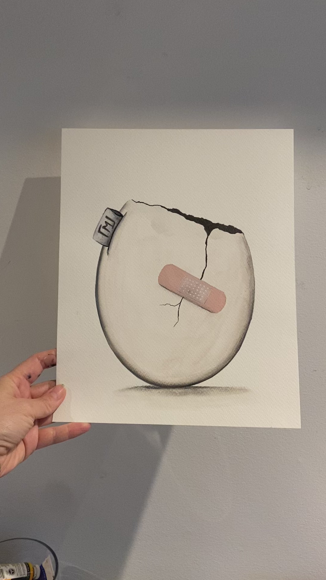 Minimalistisk maleri af æg med revne og plaster, original kunst fra 2022 af Maria Lundsten