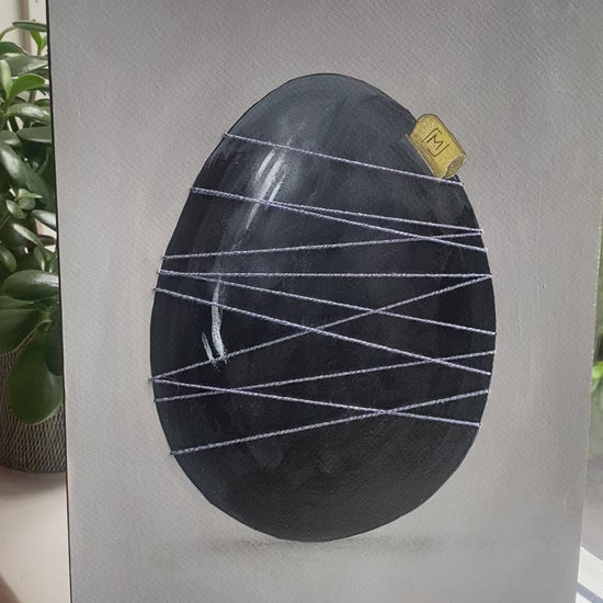 Mørkt håndmalet æg holdt sammen af blå tråd. Original kunst med roligt udtryk, synlige lag og fokus på materialitet og balance.
